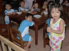 Thanh Lan Kindergarten, kinderen met borden aan tafel, meisje voorop